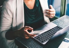 woman at notebook with smartphone